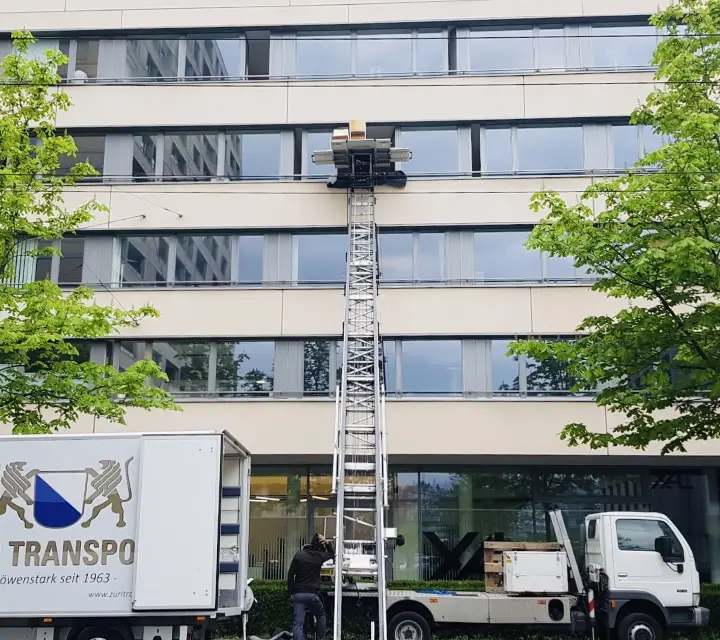 Möbellift und Umzugswagen bei einer Büroräumung vor einem Bürogebäude